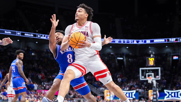 Mar 13, 2025; Kansas City, MO, USA; Arizona Wildcats forward Trey Townsend (4) drives to the basket around Kansas Jayhawks guard David Coit (8) during the first half at T-Mobile Center. Mandatory Credit: William Purnell-Imagn Images