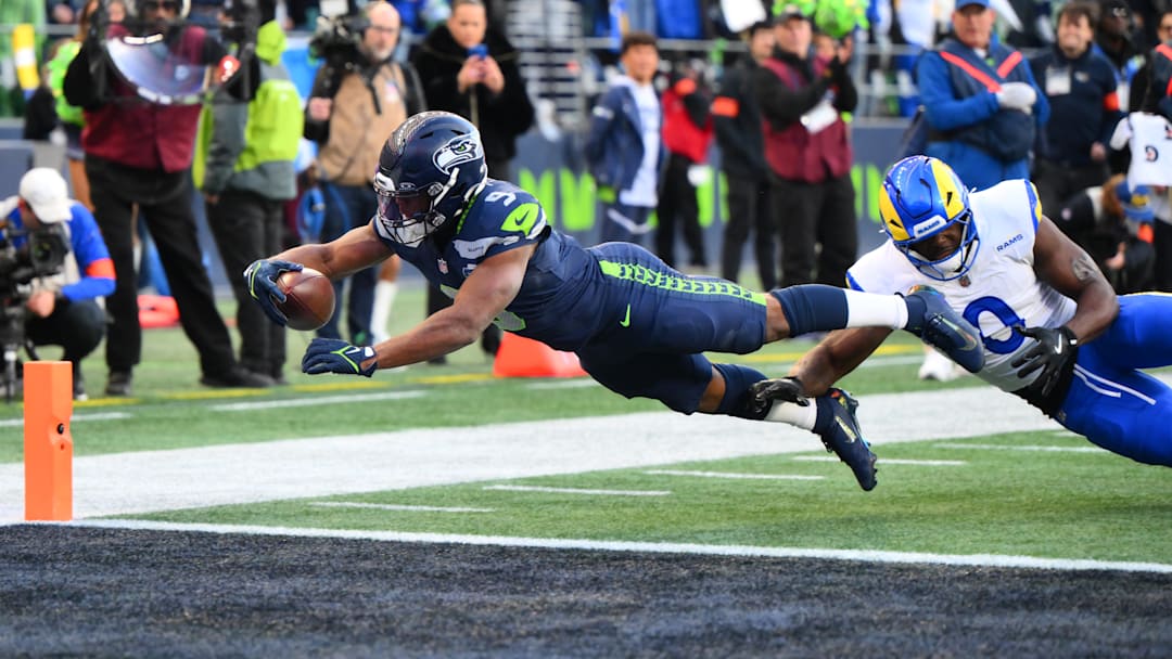 Jan 25, 2026; Seattle, WA, USA; Seattle Seahawks running back Kenneth Walker III (9) reaches for a touchdown against Los Angeles Rams linebacker Byron Young (0) in the first half in the 2026 NFC Championship Game at Lumen Field. Mandatory Credit: Steven Bisig-Imagn Images