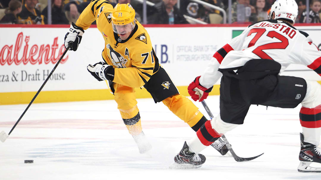 Feb 26, 2026; Pittsburgh, Pennsylvania, USA;  Pittsburgh Penguins center Evgeni Malkin (71) moves the puck against New Jersey Devils center Nick Bjugstad (72) during the third period at PPG Paints Arena. Mandatory Credit: Charles LeClaire-Imagn Images