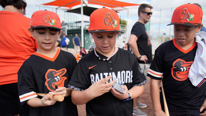 Orioles fans from Outer Banks, NC, from left, Izaiah Bravo, 10; Gabriel Bravo, 9; and Joey Robinson, 11 hope to get autographs from some of the players. The Baltimore Orioles began full-squad workouts this week at Ed Smith Stadium in Sarasota as the 2026 spring training season gets started. The Grapefruit Leage features 15 Major League Baseball teams that hold spring training in Florida. Games start this weekend and run up to opening day on March 25, 2026.