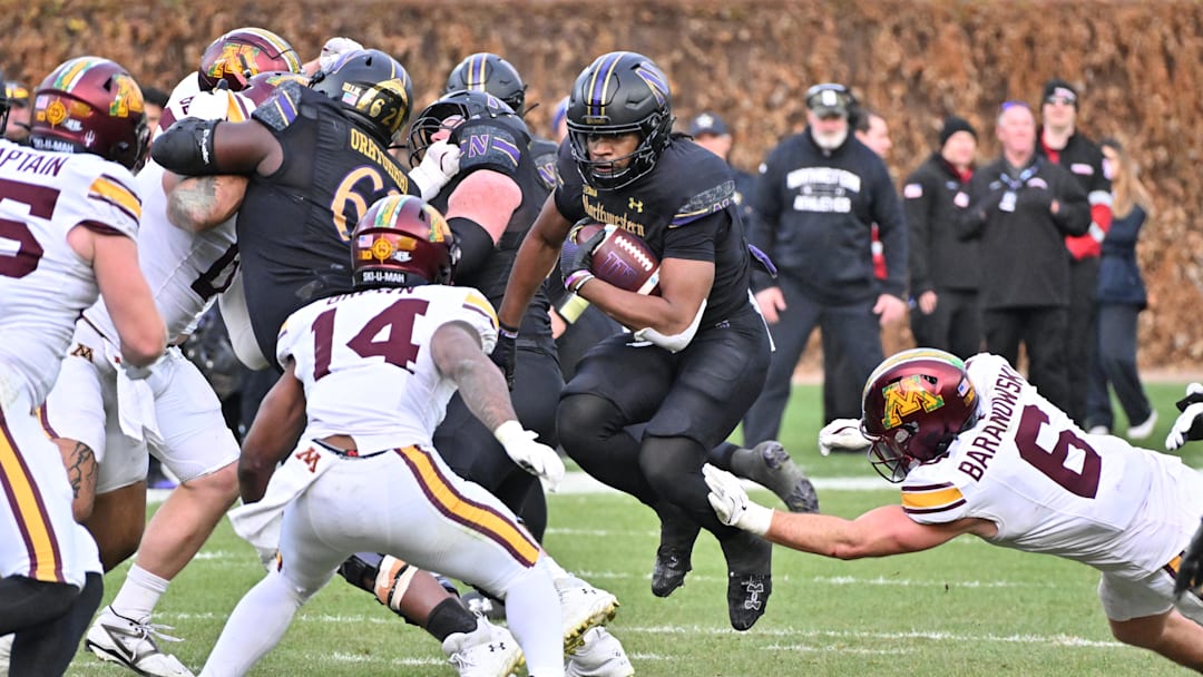 Nov 22, 2025; Chicago, Illinois, USA; Northwestern Wildcats running back Caleb Komolafe (5) runs the ball against the Minnesota Golden Gophers during the second half at Wrigley Field. Mandatory Credit: Patrick Gorski-Imagn Images