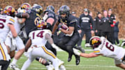 Nov 22, 2025; Chicago, Illinois, USA; Northwestern Wildcats running back Caleb Komolafe (5) runs the ball against the Minnesota Golden Gophers during the second half at Wrigley Field. Mandatory Credit: Patrick Gorski-Imagn Images