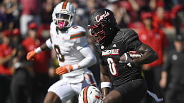 Oct 19, 2024; Louisville, Kentucky, USA; Louisville Cardinals wide receiver Chris Bell (0) runs the ball against the Miami Hurricanes during the first half at L&N Federal Credit Union Stadium. Mandatory Credit: Jamie Rhodes-Imagn Images