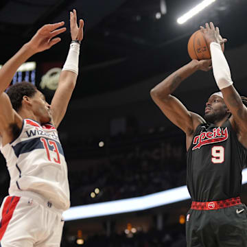 Dec 21, 2023; Portland, Oregon, USA; Portland Trail Blazers small forward Jerami Grant (9) shoots the ball over Washington Wizards shooting guard Jordan Poole (13) during the second half at Moda Center. Mandatory Credit: Soobum Im-Imagn Images