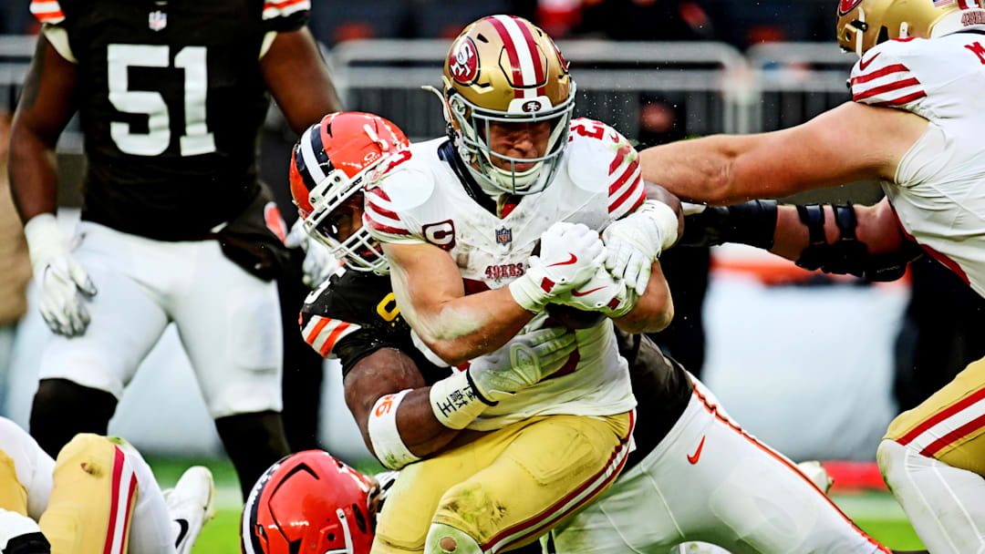 Nov 30, 2025; Cleveland, Ohio, USA;  San Francisco 49ers running back Christian McCaffrey (23) is tackled by Cleveland Browns defensive end Myles Garrett (95) during the second half at Huntington Bank Field. Mandatory Credit: Ken Blaze-Imagn Images