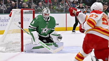 Mar 6, 2025; Dallas, Texas, USA; Dallas Stars goaltender Jake Oettinger (29) faces a shot from Calgary Flames right wing Matt Coronato (27) during the first period at the American Airlines Center. Mandatory Credit: Jerome Miron-Imagn Images