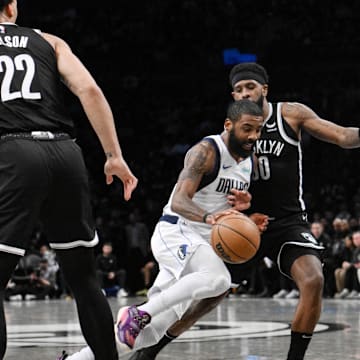 Feb 6, 2024; Brooklyn, New York, USA; Dallas Mavericks guard Kyrie Irving (11) drives to the basket as Brooklyn Nets forward Jalen Wilson (22) and forward Royce O'Neale (00) defend during the second quarter at Barclays Center. Mandatory Credit: John Jones-Imagn Images