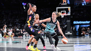 Jun 19, 2025; Brooklyn, New York, USA; New York Liberty guard Sabrina Ionescu (20) sets the play while being defended by Phoenix Mercury forward Alyssa Thomas (25) and guard Monique Akoa Makani (8) during the first half at Barclays Center. Mandatory Credit: John Jones-Imagn Images