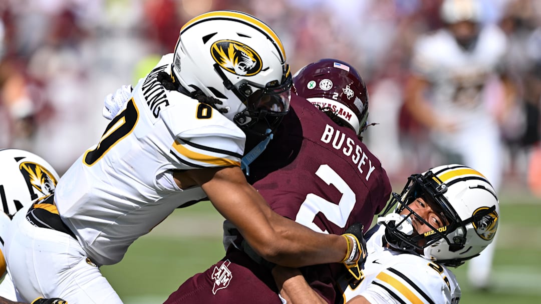 Missouri Tigers wide receiver Joshua Manning (0) and safety Joseph Charleston (28) tackle Texas A&M Aggies wide receiver Terry Bussey (2) in the first quarter at Kyle Field.