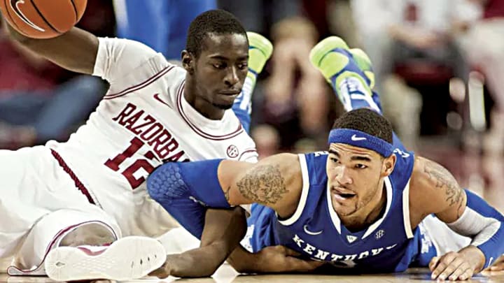 Arkansas Razorbacks guard Fred Gulley III (12) looks at Kentucky Wildcats forward Willie Cauley-Stein (15) following a scramble for a loose ball during a game at Bud Walton Arena. Arkansas defeated Kentucky 73-60. 