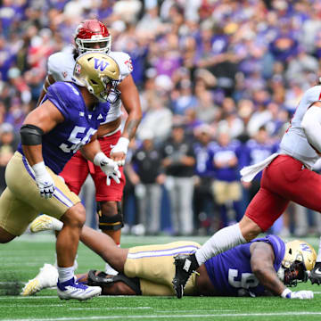 Washington State quarterback John Mateer runs through the UW defensive line in the Apple Cup.