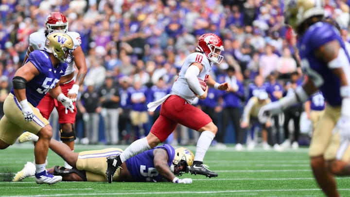 Washington State quarterback John Mateer runs through the UW defensive line in the Apple Cup.