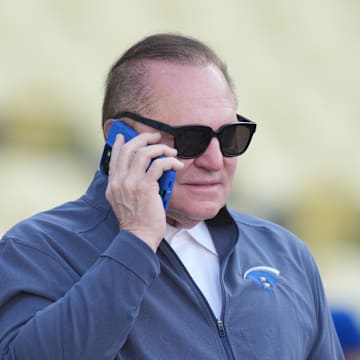 Apr 14, 2025; Los Angeles, California, USA; Sports agent Scott Boras talks on a cell phone before a game between the Colrorado Rockies and Los Angeles Dodgers at Dodger Stadium. Mandatory Credit: Kirby Lee-Imagn Images