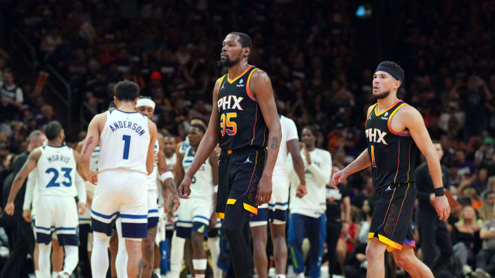 Apr 26, 2024; Phoenix, Arizona, USA; Phoenix Suns forward Kevin Durant (35) and Phoenix Suns guard Devin Booker (1) react while Minnesota Timberwolves players celebrate during the second half of game three of the first round for the 2024 NBA playoffs at Footprint Center. Mandatory Credit: Joe Camporeale-USA TODAY Sports