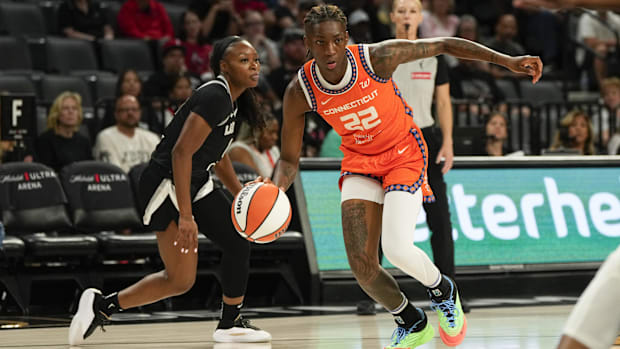 Connecticut Sun guard Saniya Rivers drives to the basket, wearing an orange jersey with a black border.