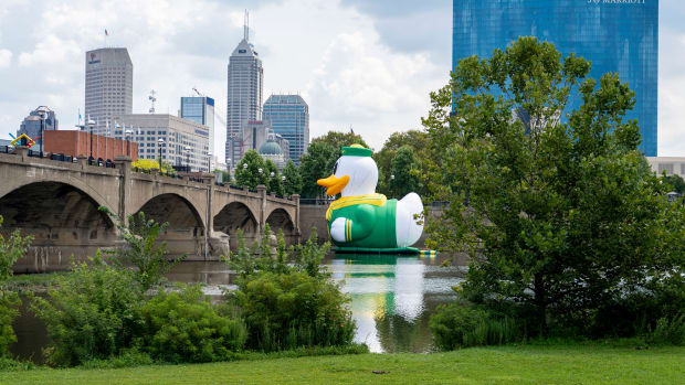 A giant inflatable Oregon Duck mascot cruises the White River in Indianapolis.