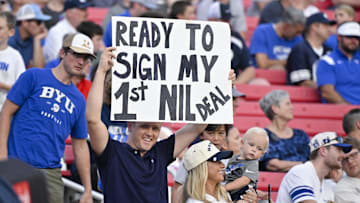 Sep 6, 2024; Dallas, Texas, USA; A view of a fan holding up an NIL sign during the first half of the game between the Southern Methodist Mustangs and the Brigham Young Cougars at Gerald J. Ford Stadium. Mandatory Credit: Jerome Miron-Imagn Images