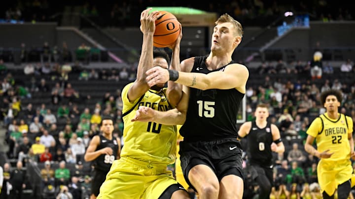 Jan 20, 2026; Eugene, Oregon, USA; Michigan State Spartans center Carson Cooper (15) blocks a drive to the basket by Oregon Ducks forward Kwame Evans Jr. (10) during the first half at Matthew Knight Arena. Mandatory Credit: Craig Strobeck-Imagn Images