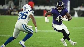 Aug 7, 2025; Baltimore, Maryland, USA; Baltimore Ravens linebacker Jay Higgins IV (49) runs back an interception in front of Indianapolis Colts running back Khalil Herbert (26) during the fourth quarter at M&T Bank Stadium. Mandatory Credit: Rafael Suanes-Imagn Images