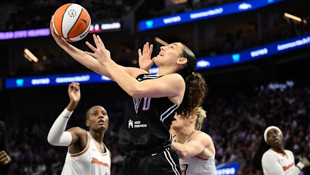 A photo of Carla Leite taking a layup