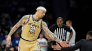 Mar 13, 2025; Charlotte, NC, USA; Georgia Tech Yellow Jackets forward Duncan Powell (31) reacts with head coach Damon Stoudamire after scoring in the first half at Spectrum Center. Mandatory Credit: Bob Donnan-Imagn Images