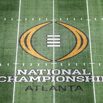 The College Football Playoff National Championship logo at midfield at Mercedes-Benz Stadium.