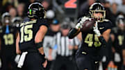 Purdue Boilermakers quarterback Ryan Browne (15) pitches the ball to running back Devin Mockobee (45) 