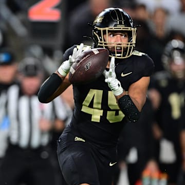 Purdue Boilermakers quarterback Ryan Browne (15) pitches the ball to running back Devin Mockobee (45) 