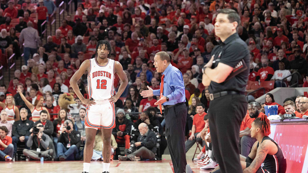 Jan 28, 2023; Houston, Texas, USA; Houston Cougars head coach Kelvin Sampson talks with Houston Cougars guard Tramon Mark (12) while Cincinnati Bearcats head coach Wes Miller watches play in the first half at Fertitta Center. Mandatory Credit: Thomas Shea-Imagn Images