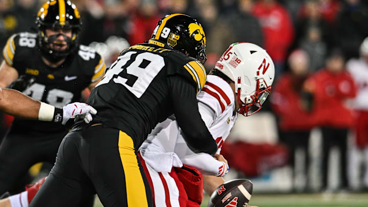 Nov 29, 2024; Iowa City, Iowa, USA; Iowa Hawkeyes defensive lineman Ethan Hurkett (49) forces a fumble as he sacks Nebraska Cornhuskers quarterback Dylan Raiola (15) during the first quarter at Kinnick Stadium. Mandatory Credit: Jeffrey Becker-Imagn Images