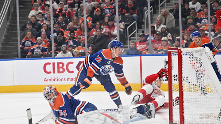 Dec 11, 2025; Edmonton, Alberta, CAN; Edmonton Oilers goalie Stuart Skinner (74) looks for the puck with Edmonton Oilers (10) center Trent Frederic as Detroit Red Wings defenseman Simon Edvinsson (77) slides past during the second period at Rogers Place. Mandatory Credit: Walter Tychnowicz-Imagn Images
