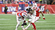 Dec 1, 2025; Foxborough, Massachusetts, USA; New York Giants wide receiver Wan'Dale Robinson (17) runs with the ball against New England Patriots safety Craig Woodson (31) during the third quarter at Gillette Stadium.  