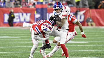Dec 1, 2025; Foxborough, Massachusetts, USA; New York Giants wide receiver Wan'Dale Robinson (17) runs with the ball against New England Patriots safety Craig Woodson (31) during the third quarter at Gillette Stadium.  