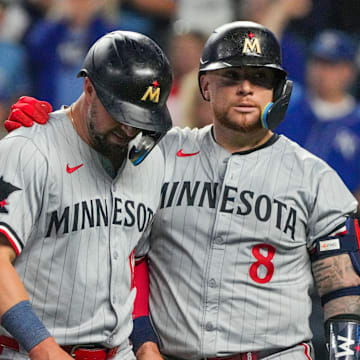 Minnesota Twins shortstop Kyle Farmer (12) reacts with catcher Christian Vázquez (8) against the Kansas City Royals after being tagged out at home in the fourth inning at Kauffman Stadium in Kansas City, Mo., on Sept. 6, 2024.