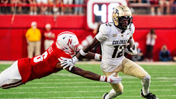 Sep 7, 2024; Lincoln, Nebraska, USA; Colorado Buffaloes wide receiver Travis Hunter (12) stiff arms Nebraska Cornhuskers defensive back Tommi Hill (6) during the second quarter at Memorial Stadium. Mandatory Credit: Dylan Widger-Imagn Images