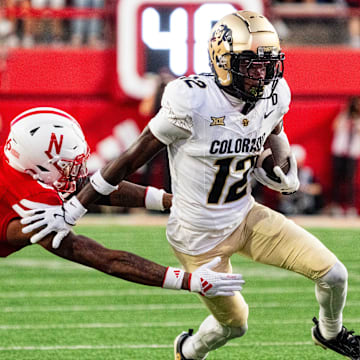 Sep 7, 2024; Lincoln, Nebraska, USA; Colorado Buffaloes wide receiver Travis Hunter (12) stiff arms Nebraska Cornhuskers defensive back Tommi Hill (6) during the second quarter at Memorial Stadium.