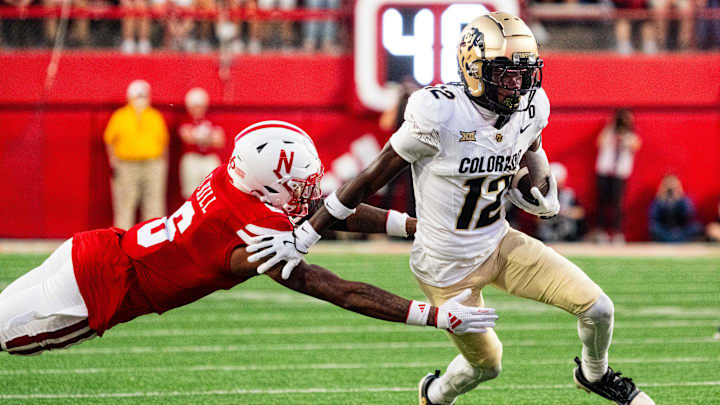 Sep 7, 2024; Lincoln, Nebraska, USA; Colorado Buffaloes wide receiver Travis Hunter (12) stiff arms Nebraska Cornhuskers defensive back Tommi Hill (6) during the second quarter at Memorial Stadium.