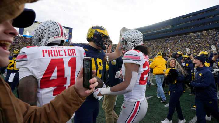 Nov. 25, 2023; Ann Arbor, Mi., USA;
Michigan Wolverines tight end Colston Loveland (18) and Ohio State Buckeyes linebacker Steele Chambers (22) meet on the field as Wolverine fans celebrate a 20-24 win following Saturday  s NCAA Division I football game at Michigan Stadium.