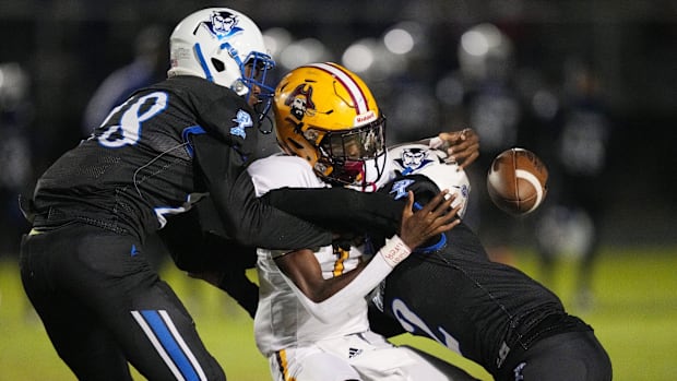 Glades Central QB Taj Barnes (17) fumbles after getting hit by Hardley Gilmore (2) and Kani Smith (28) of Pahokee in 2023.