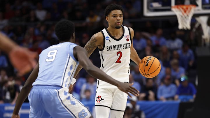 Mar 18, 2025; Dayton, OH, USA; San Diego State Aztecs guard Nick Boyd (2) dribbles the ball defended by North Carolina Tar Heels guard Drake Powell (9) in the first half  at UD Arena. Mandatory Credit: Rick Osentoski-Imagn Images