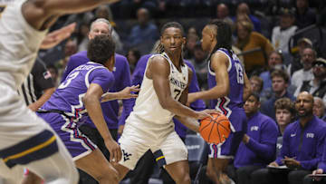 Feb 25, 2025; Morgantown, West Virginia, USA; West Virginia Mountaineers guard Javon Small (7) looks to pass while defended by TCU Horned Frogs guard Vasean Allette (3) during the first half at WVU Coliseum. Mandatory Credit: Ben Queen-Imagn Images