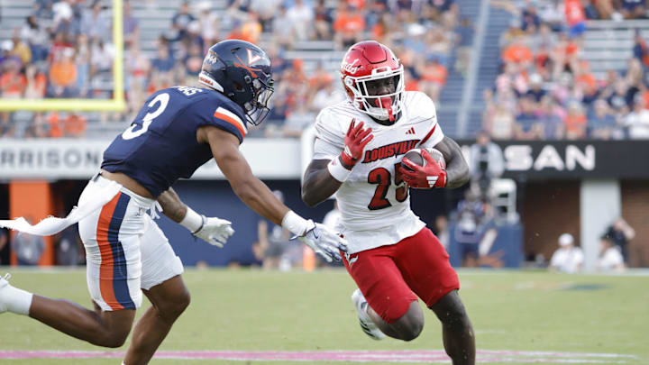 Oct 12, 2024; Charlottesville, Virginia, USA; Louisville Cardinals running back Isaac Brown (25) carries the ball past Virginia Cavaliers safety Corey Thomas Jr. (3) to score a touchdown during the second half at Scott Stadium. Mandatory Credit: Amber Searls-Imagn Images