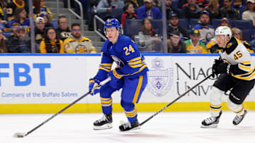 Apr 6, 2025; Buffalo, New York, USA;  Buffalo Sabres defenseman Jacob Bernard-Docker (24) looks to make a pass as Boston Bruins left wing Cole Koepke (45) tries to defend during the first period at KeyBank Center. Mandatory Credit: Timothy T. Ludwig-Imagn Images