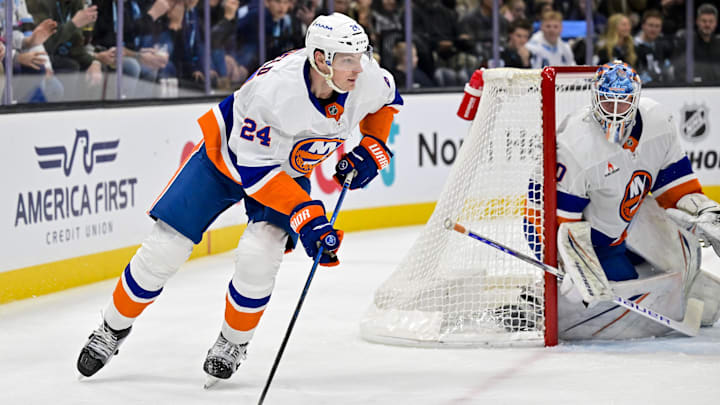 Jan 11, 2025; Salt Lake City, Utah, USA; New York Islanders defenseman Scott Mayfield (24) moves the puck behind the goal against the Utah Hockey Club during second period at the Delta Center. Mandatory Credit: Christopher Creveling-Imagn Images