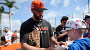Orioles right-hand pitcher Grayson Rodriguez signs an autograph for fan Charlie Brose, 11, from Pittsburgh, Pennsylvania. The Baltimore Orioles held their first full-squad workout of spring training on Tuesday, Feb. 18, 2025.