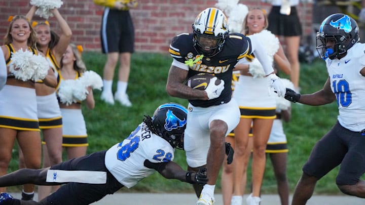 Sep 7, 2024; Columbia, Missouri, USA; Missouri Tigers wide receiver Theo Wease Jr. (1) runs the ball as Buffalo Bulls cornerback Marquis Cooper (28) attempts the tackle during the first half at Faurot Field at Memorial Stadium. Mandatory Credit: Denny Medley-Imagn Images