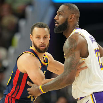 Jan 25, 2025; San Francisco, California, USA; Golden State Warriors guard Stephen Curry (left) defends against Los Angeles Lakers forward LeBron James (right) during the fourth quarter at Chase Center. Mandatory Credit: Darren Yamashita-Imagn Images
