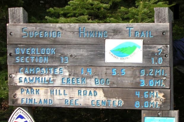 A sign listing the distances of checkpoints on the Superior Hiking Trail.