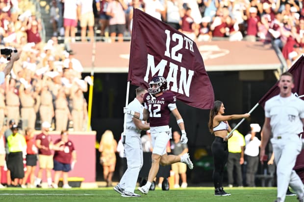 Texas A&M Aggies linebacker Sam Mathews (12) runs the 12th Man flag out prior to the game against the New Mexico Lobos. 