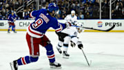 Oct 12, 2024; New York, New York, USA; New York Rangers defenseman Jacob Trouba (8) shoots the puck as Utah Hockey Club left wing Matias Maccelli (63) defends during the second period at Madison Square Garden. Mandatory Credit: John Jones-Imagn Images
